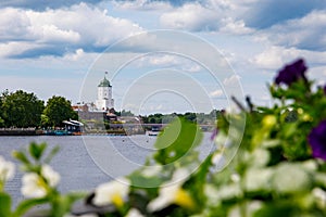 Vyborg Castle Swedish-built with Olaf's Tower with russian flag on roof. View from embankment of Salakkalahti bay