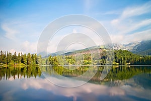 Vysoké Tatry, Štrbské Pleso, Slovensko - zrcadlení stromů na vodní hladině s potápěčskou plošinou. Krásné Slovensko. Dlouho ti