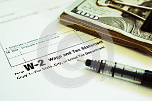 W-2 Employee Internal Revenue Service  IRS Tax Form Close Up With Money And Fine Point Pen With Lomo Effect photo