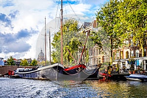 Waalseiland Canal with its historic canal houses, houseboats and commercial river boats in the old city center of Amsterdam