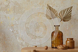 Wabi sabi interior of living room with wooden console, paper flowers in vase, nuts and copy space. Minimalistic concept. photo