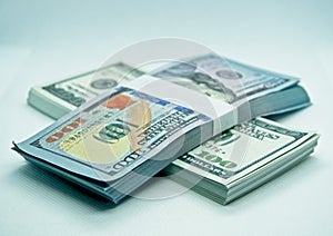 Wad of 100 dollar bills in a white background.