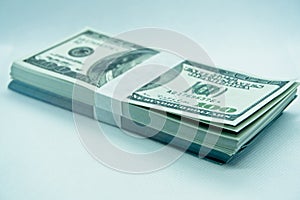 Wad of 100 dollar bills in a white background