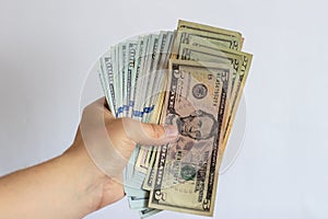 A wad of dollars in his hands on a white background. Dollar bills on a white background