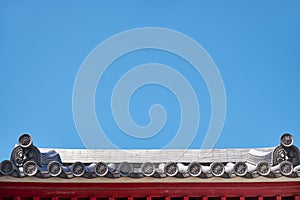 The wadangs adorned with moulded designs on the roof of traditional Japanese shrine. Osaka. Japan