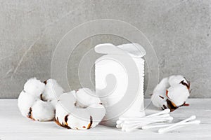 Wadded pads, sticks and cotton flowers on the wooden table photo