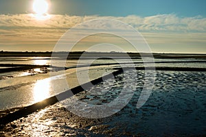 Wadden Sea of the North Sea with the sun above the clouds and view over the silt on the mainland, Sylt, Germany