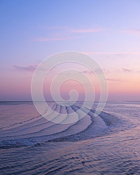 Waddenzee or wadd sea during sunset seen from jetty of ameland ferry