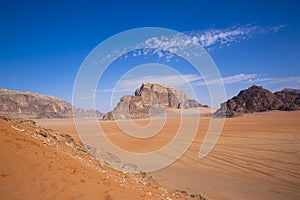 Wadi Rum desert in Jordan. Beautiful red pink sand dunes and rocky mountains, beautiful blue sky