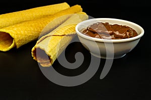 Wafer rolls with condensed milk on a white plate