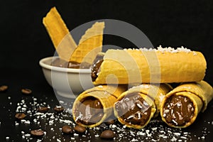 Wafer rolls with condensed milk on a white plate