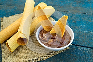 Wafer rolls with condensed milk on a white plate