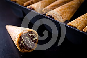 Wafer rolls filled with butter cream and chocolate crisps