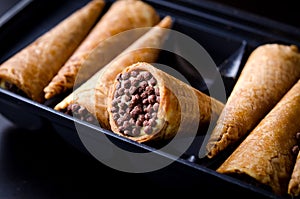 Wafer rolls filled with butter cream and chocolate crisps