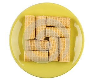 Wafer rolls in yellow saucer isolated on white