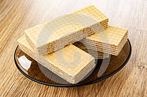 Wafers in brown saucer on wooden table
