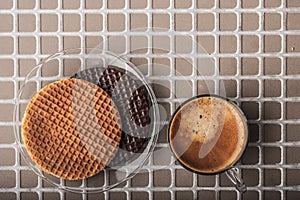 Wafers with cup of coffee on the relief background top view