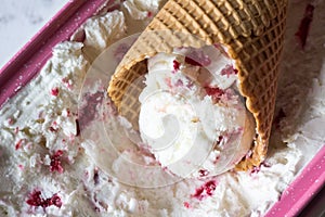 Waffel cone filled with homemade Ice cream  made with Greek yogurt and raspberry. Summer refreshment and healthy dessert. Recipe