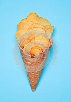 Waffle Cone with Potato Chips on blue background. Fast Food concept