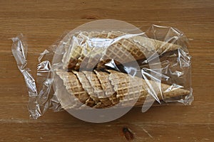 waffle cones in plastic packaging on a wooden table