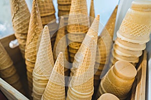 Waffle cones ready to be filled with ice cream stocked up in a wooden container