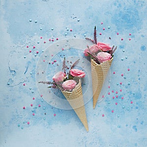 Waffle horns with flowers on blue background, Tenderness, St. Valentine`s Day, Top view