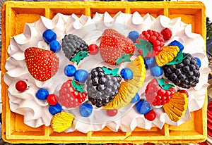 Waffle with ice cream, strawberries and other fruits as a plastic sign