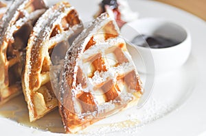 Waffle with icing sugar and blueberry dip