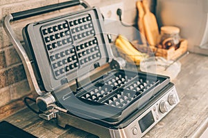 Waffle iron on kitchen table. Home kitchen interior
