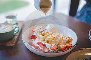 Waffle pancake desert with vanilla ice cream, fresh strawberry and honey syrup