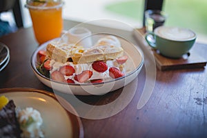 Waffle pancake desert with vanilla ice cream, fresh strawberry and honey syrup