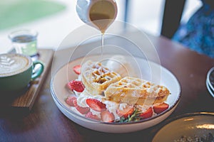 Waffle pancake desert with vanilla ice cream, fresh strawberry and honey syrup