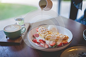 Waffle pancake desert with vanilla ice cream, fresh strawberry and honey syrup