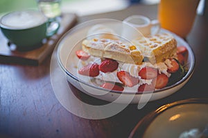 waffle pancake desert with vanilla ice cream, fresh strawberry and honey syrup