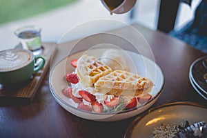 waffle pancake desert with vanilla ice cream, fresh strawberry and honey syrup