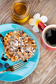 Waffles with berries on wooden background