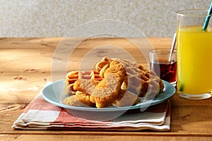 Waffles with chicken tenders and maple syrup