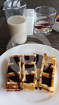 Waffles with chocolate topping are one of the most delicious snacks, coupled with fresh milk drinks