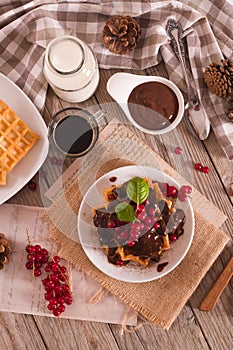 Waffles with chocolate topping and red currant.