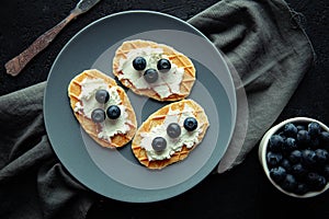 Waffles with cream cheese and fresh blueberries.