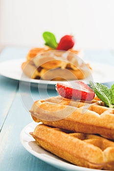 Waffles with ice cream on a blue wooden table