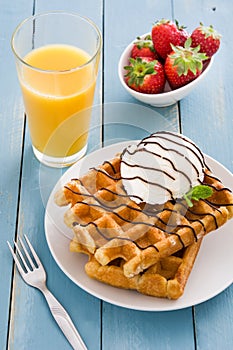 Waffles with ice cream on a blue wooden table