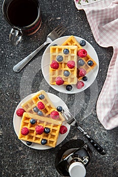 Waffles, maple sirup, blueberries and raspberries