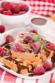 Waffles with raspberries and chocolate cream.