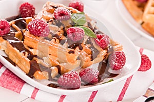 Waffles with raspberries and chocolate cream.