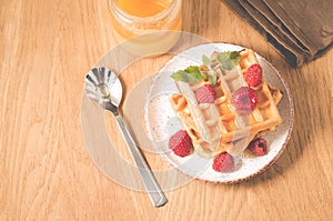 Waffles With raspberry in plate. Sweet dessert menu. Breakfast/Homemade waffles with raspberry, honey in plate on a old wooden