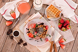 Waffles with strawberries and chocolate cream