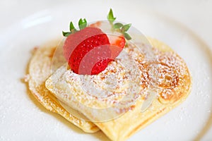 Waffles with strawberries and icing sugar