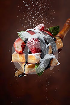 Waffles with strawberries, mint and chocolate sauce