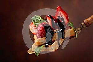 Waffles with strawberries, mint and chocolate sauce